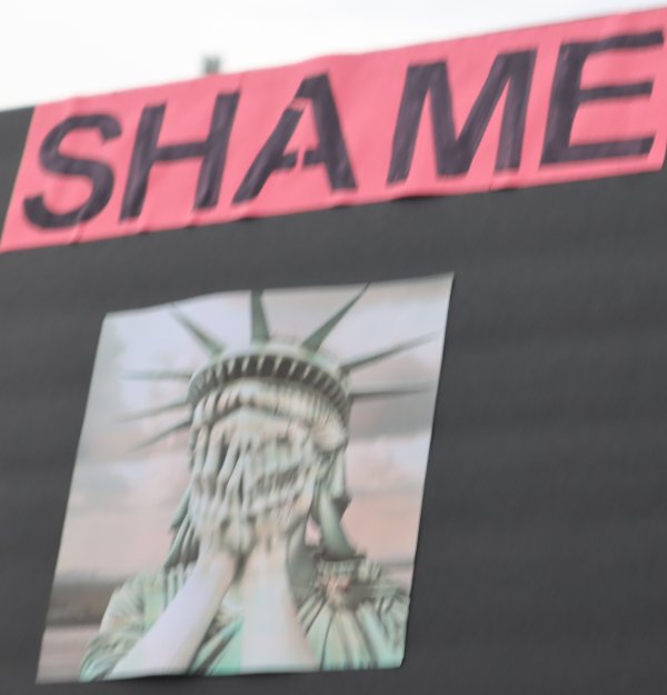 Sign with word Shame and Lady Liberty with hands over face